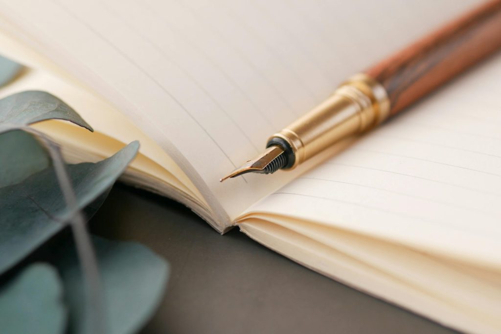 A closeup of a luxurious fountain pen resting on a lined notebook, perfect for writing enthusiasts.